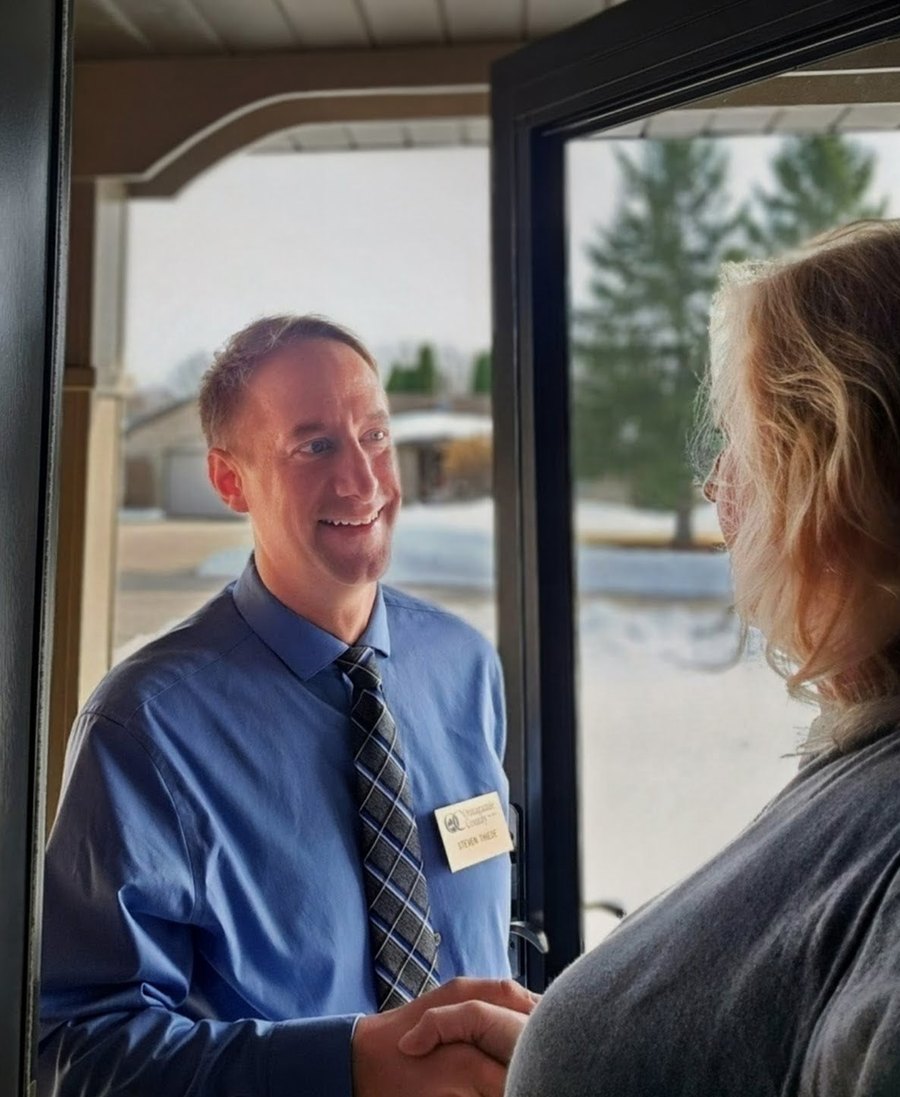 Steve Thiede greeting a resident at the door